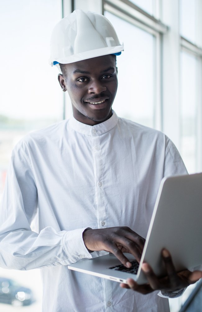 African american architect working with computer and blueprints in office