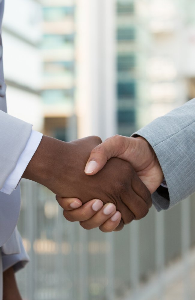 Multiethnic leaders greeting each other in city. Closeup of business man and woman shaking hands outside. Cooperation concept